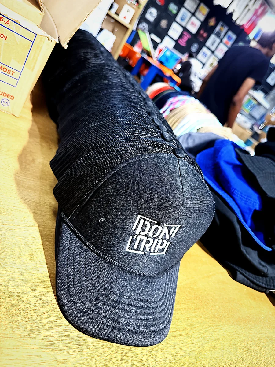 A stack of freshly embroidered black trucker hats