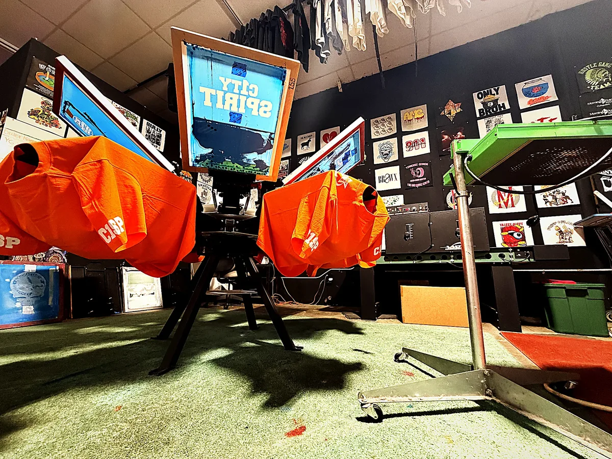 A run of orange tees drying around the carousel press